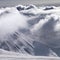 Ski slope and mountains in sunlight storm clouds before snowfall