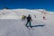 Ski slope with skier under blue sky. People drive down the snowy mountains on skis. Group of