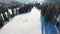 Ski slope. Skiers and snowboarders roll down the track. Aerial photography of a skier descending a wide ski slope