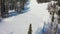 Ski slope. Skiers and snowboarders roll down the track. Aerial photography of a skier descending a wide ski slope