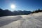 The ski slope with a view on Dolomiti mountains and sun