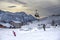 Ski slopes with skiers at sunset. Trentino, Italy