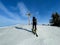 Ski tourer approaching wooden summit cross in Austrian Alps. Laterns, Vorarlberg, Austria.