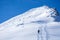 Ski tourer snow shoe hiker climbing the mountain, blue sky sunny
