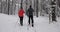 Ski touring in deep fresh snow - young couple skiing in snowy winter forest