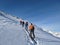 Ski touring group on the way to the summit. Mountaineering with skis in winter on the Gemsfairenstock in Uri. Swiss Alps