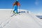 Ski touring man reaching the top at sunny day.