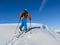 Ski touring man reaching the top at sunrise.