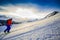 Ski touring man reaching the top at sunrise.