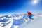 Ski touring man reaching the top in Swiss Alps.