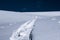 Ski touring track in powder snow with blurred skier background