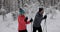 Ski touring - young couple skiing in snowy winter forest