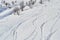 Ski tracks on powder snow at Les Sybelles ski domain, France, on a sunny Winter day