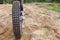 Skid-resistant tread on motorcycle tire, motocross bike in sandy track, rear view