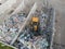 Skid steer loader moving garbage at the landfill site, drone shot