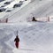 Skier ascend on snow ski slope at sun evening