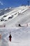 Skier ascend on snow ski slope at sun evening