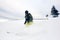 Skier in deep powder on snow-capped downhill. Extreme skiing concept. Grey sky and pine tree on background. Front view.
