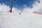 Skier descend on snowy ski slope at sun winter day