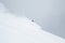 Skier disappearing in soft snow in backcountry ski turn through deep snow in Hokkaido, Japan