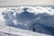 Skier downhill on ski slope and sunlight storm clouds