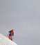 Skier before downhill on snowy freeride slope and misty sky