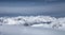 Skier following track leading into valley over untracked snow field