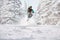 Skier freerides and jumps in snowy forest