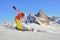 Skier in front of Seceda ridge in Dolomites mountains, Italy, during Winter. Woman with colorful clothing posing.