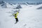 A skier in full sports equipment jumps into the abyss from the top of the glacier against the background of the blue sky