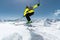 A skier in full sports equipment jumps into the abyss from the top of the glacier against the background of the blue sky