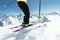 A skier in full sports equipment jumps into the abyss from the top of the glacier against the background of the blue sky