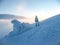 Skier girl in blue jumpsuit on blue slope near the icy snowdrift. Mountain winter landscape in the Carpathians in Ukraine