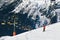 Skier going down the slope under ski lift. Cable car in mountains