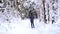 Skier in hat with pompom with ski poles in his hands with in snowy forest with snow. Cross-country skiing in winter forest, outdoo