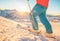 Skier having fun at sunset on top of the mountain - Legs view of young man standing in ski slope - Sport, travel and vacation