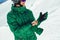 Skier in a helmet with a ski mask standing on a glacier is preparing to jump wearing membrane gloves