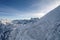 Skier hiker slowy walk down on a massive snow mountain slope on top of alps mont blanc