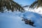 Skier hiking toward the Asulkan Glacier past a waterfall on bright sunny spring day