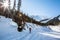 Skier hiking toward the Seven Steps of Paradise run down Young`s Peak. The Asulkan Valley is lit by the morning sun around him