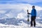 Skier holding skis in hand and looking at beautiful snow covered landscape near Chamonix Mont Blanc, France