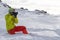 Skier man with orange ski glasses in green helmet make photoshoot on top in Alps mountains. On the background of