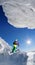 Skier on monoski in high mountains against blue sky