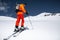 A skier in an orange suit skis in a mountain off-piste skiing in the northern caucasus of Mount Elbrus