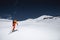 A skier in an orange suit skis in a mountain off-piste skiing in the northern caucasus of Mount Elbrus