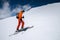 A skier in an orange suit skis in a mountain off-piste skiing in the northern caucasus of Mount Elbrus