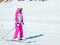 A skier in a pink suit and with a closed face rides a straight track on a sunny winter day
