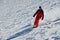 Skier in red suit going down the slope on a sunny day
