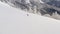 Skier riding freeride on ski from snowy slope in winter mountain pine forest