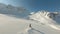 Skier riding on mountain ski from snowy downhill aerial view from fpv drone. Sportsman skiing on mountain slope in